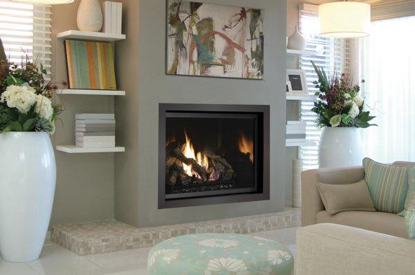 A beautifully installed gas fireplace insert with realistic logs and embers with a warm fire burning.