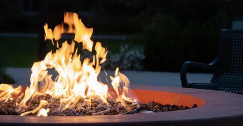 Close-up of a lit fire pit at night in a backyard