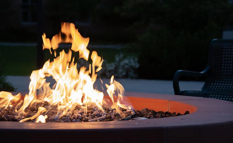 Close-up of a lit fire pit at night in a backyard