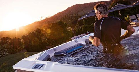 man exercising in a swim space system outside with a sunset