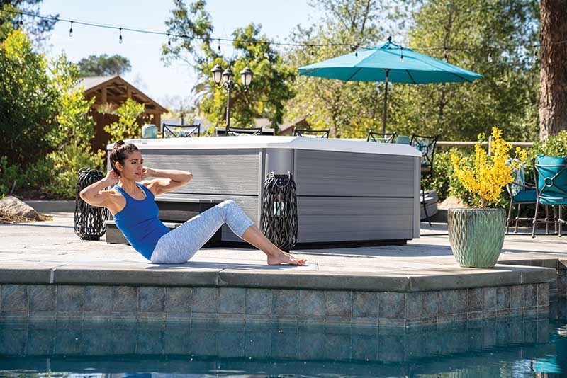 women exercising in her backyard next to her hot tub