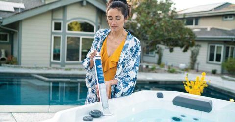 women using hot tub maintenance products to keep her spa clean