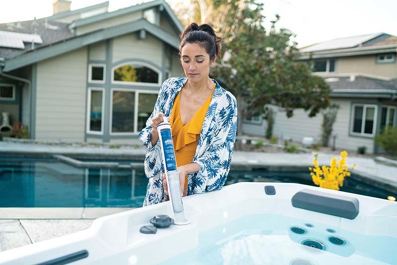 women using hot tub maintenance products to keep her spa clean
