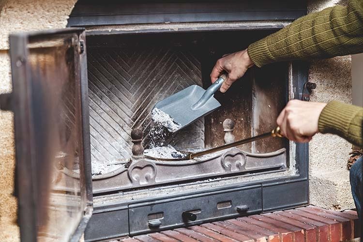 person cleaning a fireplace in springtime