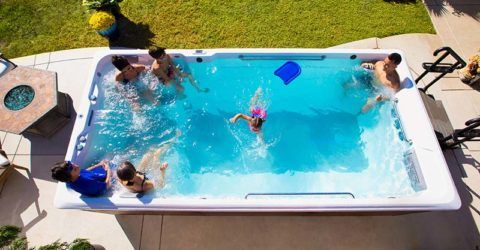 large family enjoying their endless pools swim spa in their backyard during the summer