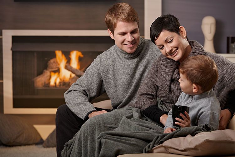 happy family sitting in front of their fire place smiling