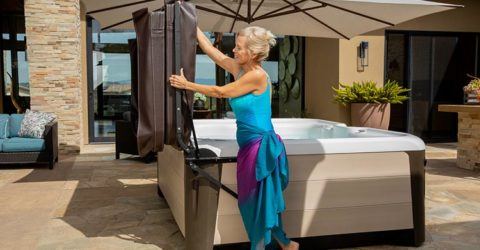 Gray-haired woman using hydraulic hot tub cover