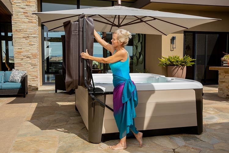 Gray-haired woman using hydraulic hot tub cover