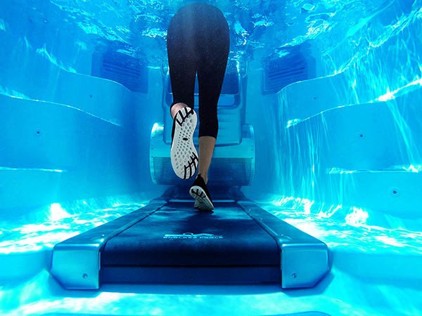 women running underwater on an aquatic treadmill in an Endless Pool Swim Spa