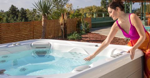 women in backyard looking into her hotsprings spa at brilliantly clean and clear hot tub water