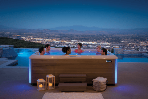 Group of people sitting in hot tub overlooking city