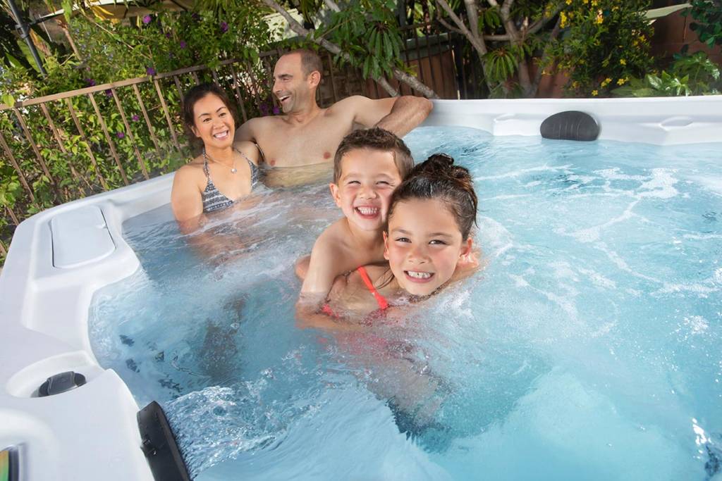 family of four enjoying hot tub