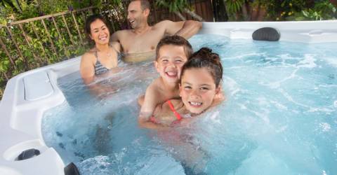 family of four enjoying hot tub