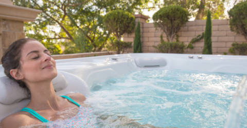 Woman enjoying hot tub hydrotherapy in backyard