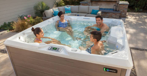 family of four in backyard hot tub