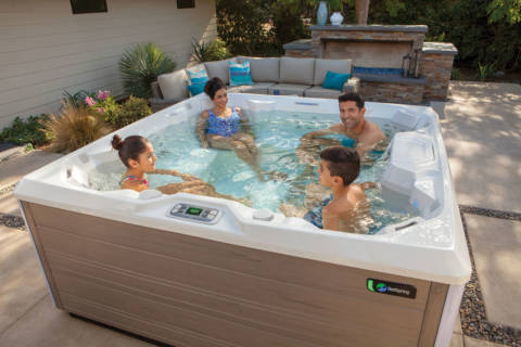 family of four in backyard hot tub