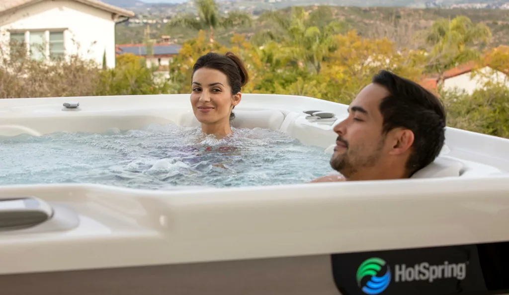 Couple enjoying HotSpring Spa with house and open land in background