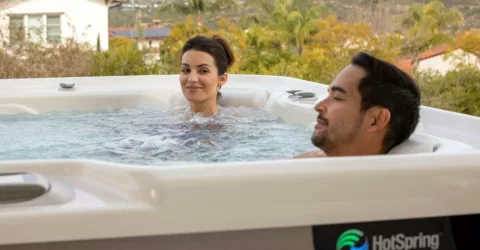 Couple enjoying HotSpring Spa with house and open land in background