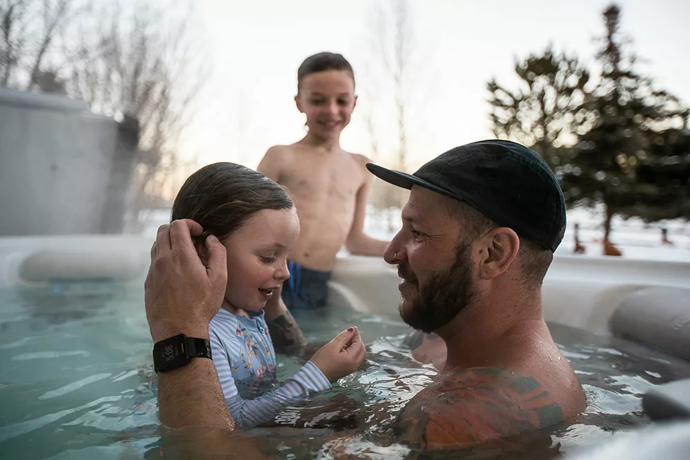Johnny Action in hot tub with his kids in the winter. 