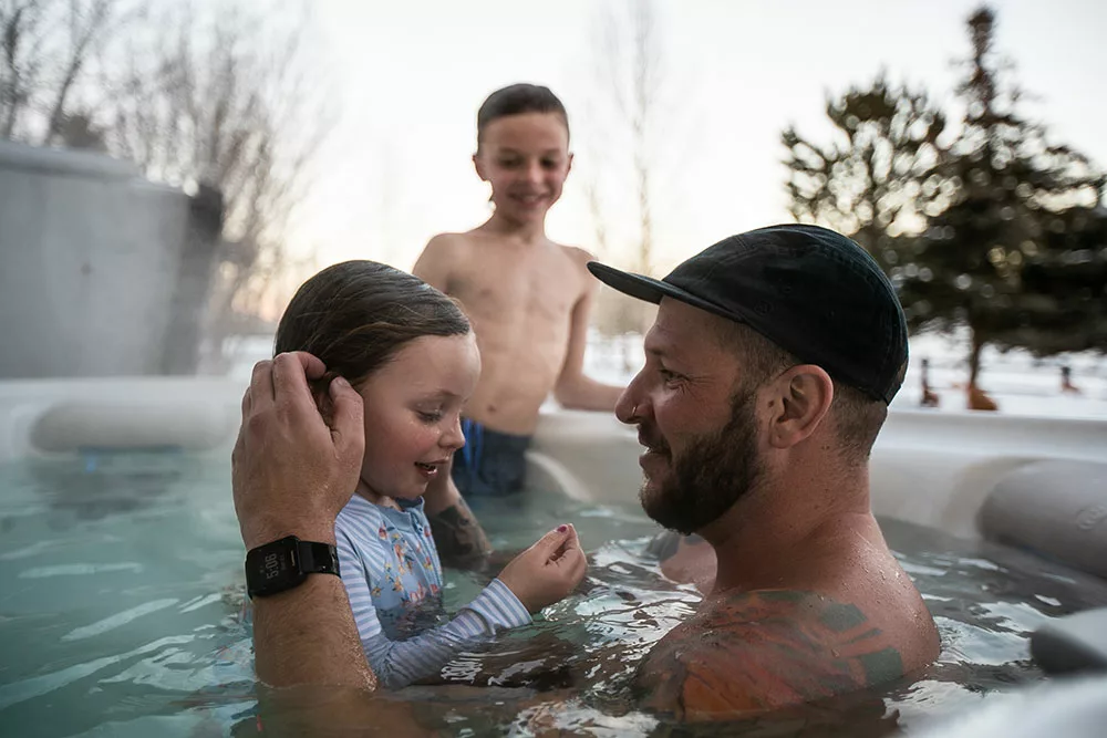 Johnny Action in hot tub with his kids in the winter.