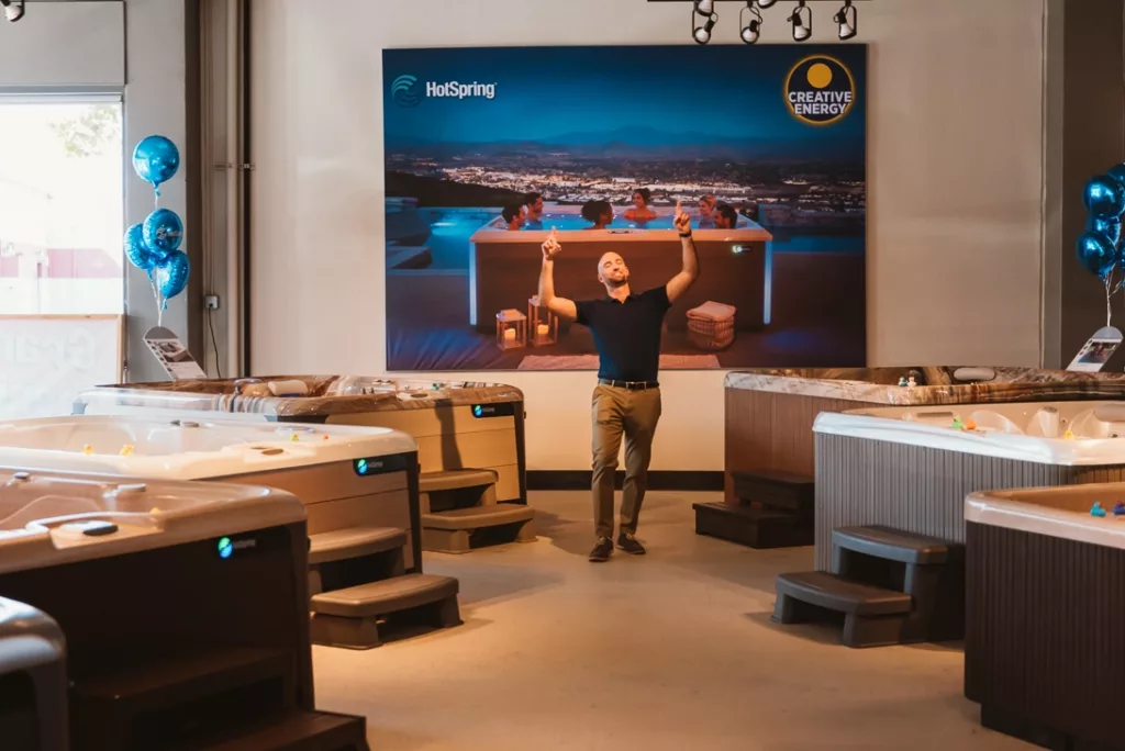 Interior of the Creative Energy San Rafael Showroom featuring multiple Hot Spring hot tub floor models and a friendly employee