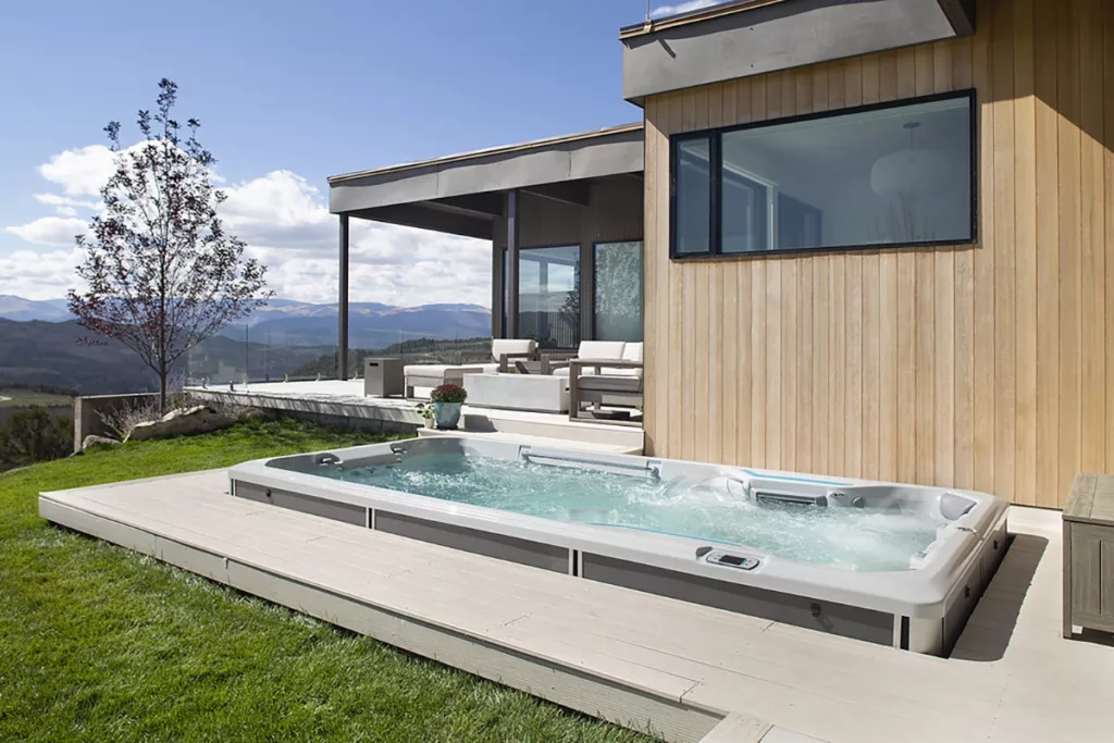 A beautiful swim spa installed in the small backyard of a modern home