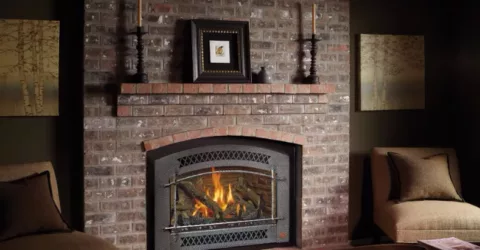 A gas fireplace insert in a brick fireplace.