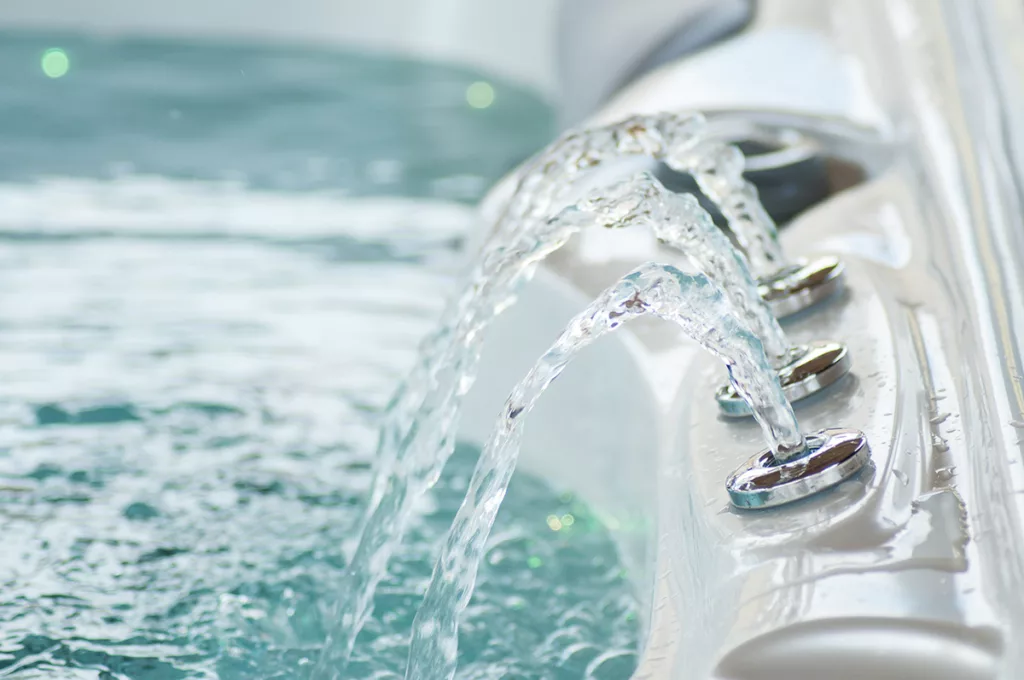 A close up shot of a hot tub filled with water, and hot tub jets.