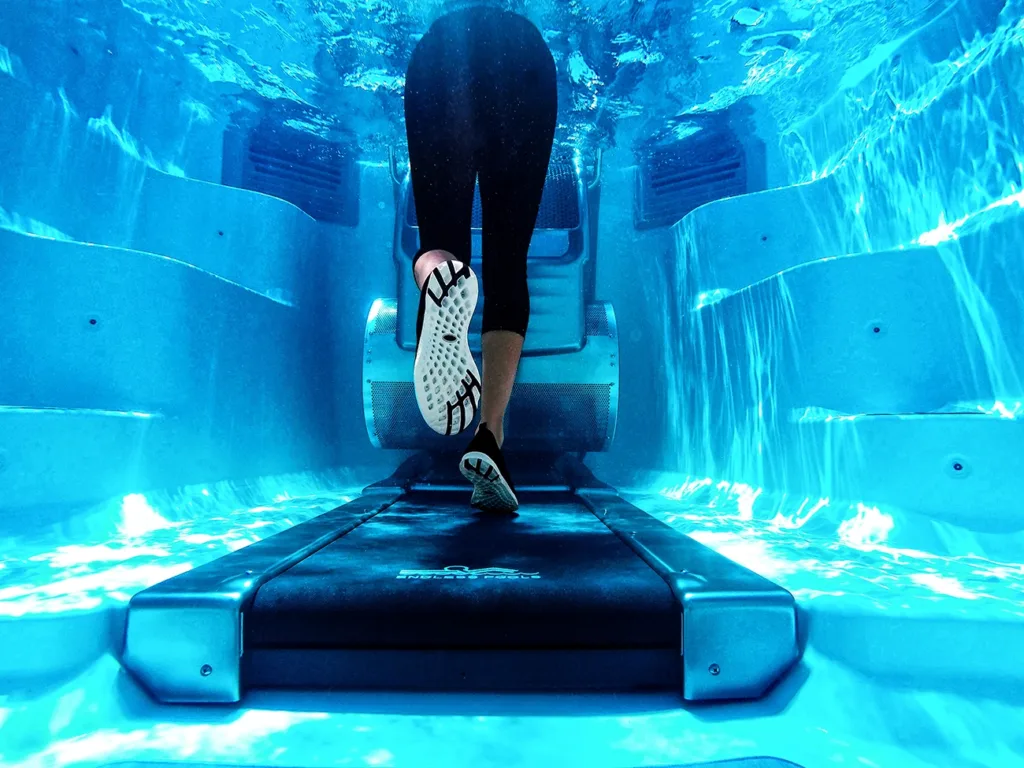 a muscular women running on an underwater treadmill in a swim spa