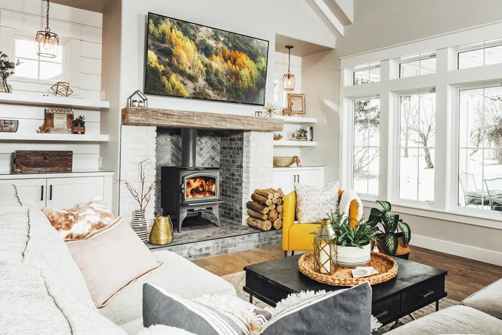 A Lopi Answer NexGen Hybrid wood-burning stove, in a bright and airy living room with a white brick fireplace